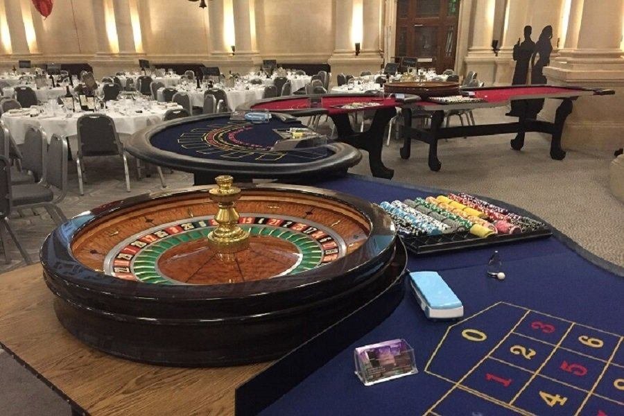 Roulette table set up at a gala dinner with guests seated around tables